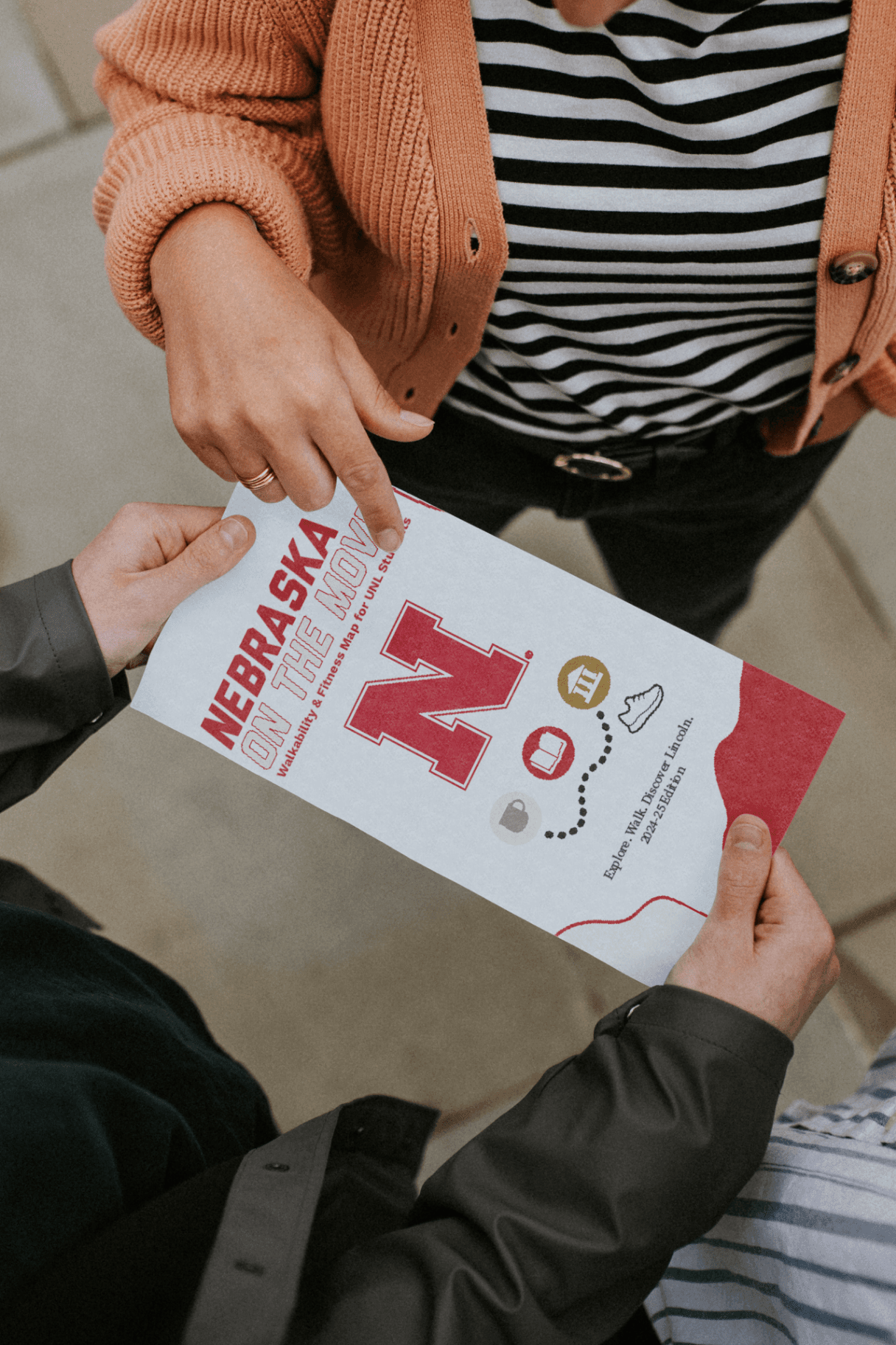Hand holding the folded Nebraska on the Move map